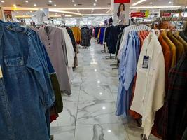 jombang, oosten- Java, Indonesië, 2022 - rijen van vrouwen en Mannen kleding, zo net zo overhemden, jurken, broek, rokken, van divers merken. portret van kleding Product Scherm in een boodschappen doen centrum foto