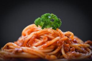 spaghetti Italiaans pasta dichtbij omhoog spaghetti bolognese Aan zwart achtergrond foto