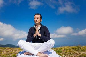 kalmte Mens in namaste houding mediteren Aan berg piek. foto