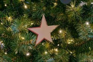 dichtbij omhoog van feestelijk nieuw jaar boom met een ster in pastel kleuren. modieus decoratie voor winter vakantie foto