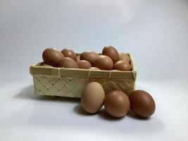 kip eieren in een bamboe mand Aan een wit achtergrond foto