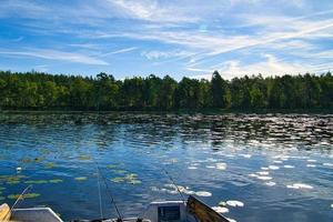 een visvangst boot Aan een meer in Zweden in klein en. blauw water, zonnig lucht, bossen foto