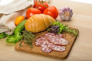 salami Aan houten bord en houten achtergrond foto