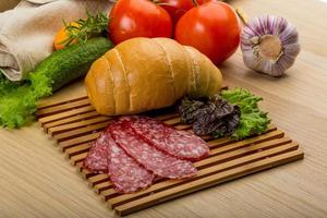 salami Aan houten bord en houten achtergrond foto