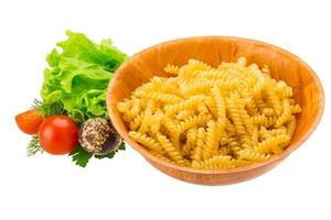 fusilli pasta in een kom op witte achtergrond foto