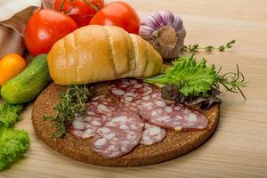 salami Aan houten bord en houten achtergrond foto