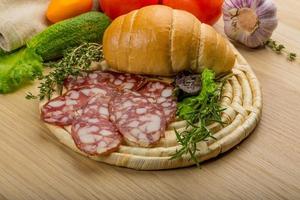 salami Aan houten bord en houten achtergrond foto