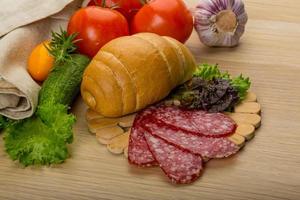 salami Aan houten bord en houten achtergrond foto