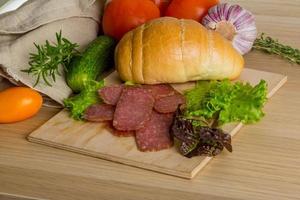 salami Aan houten bord en houten achtergrond foto