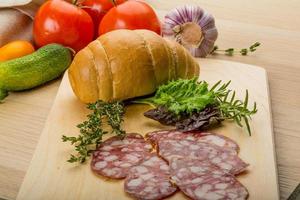 salami Aan houten bord en houten achtergrond foto