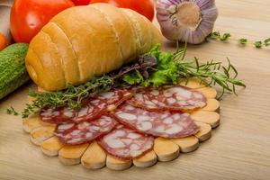 salami Aan houten bord en houten achtergrond foto