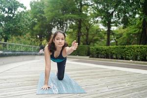 jong aantrekkelijk vrouw aan het doen uitrekken yoga oefening in de park. foto