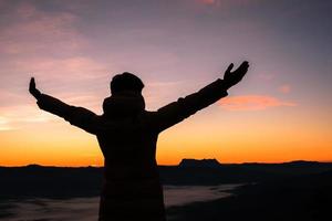 silhouet van menselijk persoon handen Open palm omhoog aanbidden in lucht zonsondergang of zonsondergang. Katholiek volwassen Mens bidden en hoop Aan berg. christen religie concept achtergrond. vechten en zege voor god foto