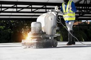 bouw arbeiders gebruik een machine naar Pools en af hebben oppervlakken of epoxy beton Aan de huis plaats. foto