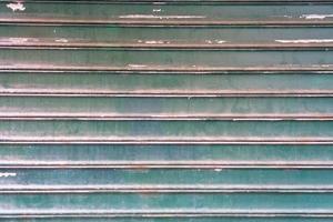 vuil getextureerde staal garage deur geschilderd in groente, achtergrond, gestreept metaal gekleurde Luik muur, abstract horizontaal lijnen, grunge structuur en patroon. foto