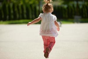 weinig meisje hebben pret in park foto