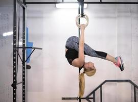 vrouw werken uit Aan gymnastiek- ringen foto