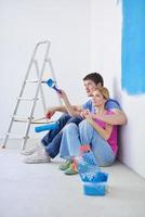 gelukkig jong cople ontspannende na schilderij in nieuw huis foto