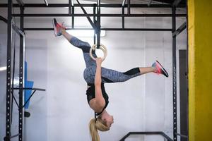 vrouw werken uit Aan gymnastiek- ringen foto