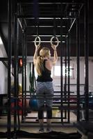 vrouw werken uit Aan gymnastiek- ringen foto