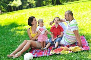 gelukkig jong koppel met hun kinderen veel plezier in het park foto