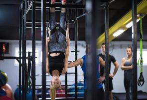 vrouw werken uit met persoonlijk trainer Aan gymnastiek- ringen foto