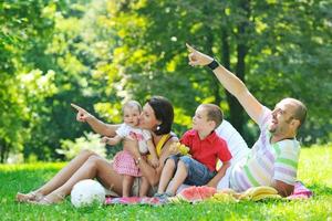 gelukkig jong koppel met hun kinderen veel plezier in het park foto