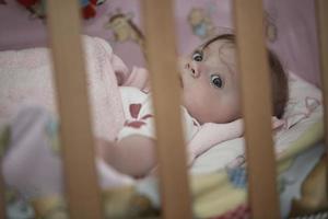 schattig weinig baby spelen met handen en glimlachen foto