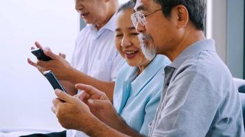 groep van senior vrienden gebruik makend van slim telefoon in een pensioen huis foto