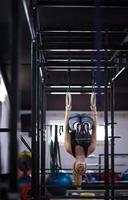 vrouw werken uit Aan gymnastiek- ringen foto