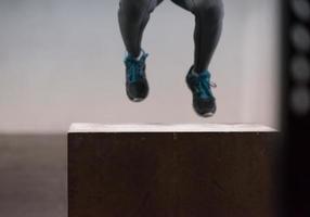 zwart vrouw is het uitvoeren van doos springt Bij Sportschool foto