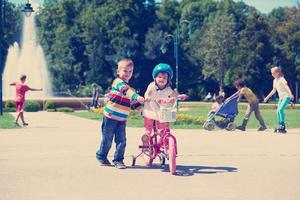 jongen en meisje in park aan het leren naar rijden een fiets foto