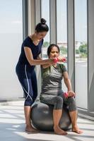 twee Aziatisch Dames aan het doen yoga samen Bij een Sportschool. foto