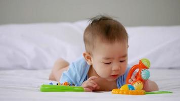 aanbiddelijk weinig baby spelen een speelgoed- Aan bed. foto