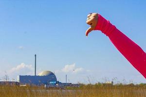 afkeer en duim naar beneden naar atomair nucleair macht station duitsland. foto