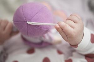 schattig weinig baby spelen met handen en glimlachen foto