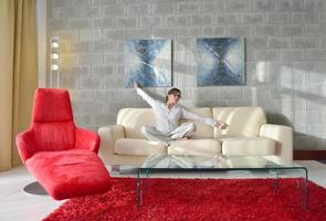 gelukkig jong vrouw kom tot rust Bij huis Aan sofa foto