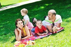 gelukkig jong koppel met hun kinderen veel plezier in het park foto