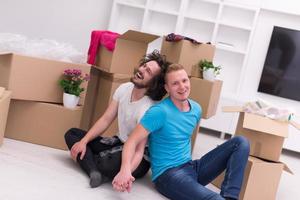 jong homo paar in beweging in nieuw huis foto
