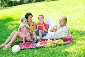 gelukkig jong koppel met hun kinderen veel plezier in het park foto