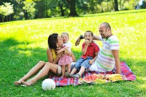 gelukkig jong koppel met hun kinderen veel plezier in het park foto