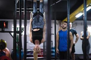 vrouw werken uit met persoonlijk trainer Aan gymnastiek- ringen foto