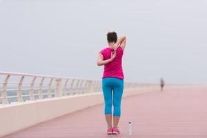 vrouw uitrekken en opwarming omhoog Aan de promenade foto