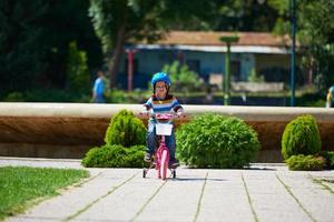 gelukkig jongen aan het leren naar rijden zijn eerste fiets foto