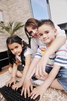 gelukkig jong familie hebben pret en werken Aan laptop Bij huis foto