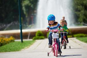 gelukkig jongen aan het leren naar rijden zijn eerste fiets foto