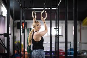 vrouw werken uit Aan gymnastiek- ringen foto