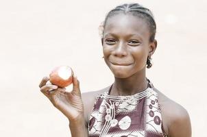 prachtig Afrikaans zwart schoolmeisje dat een appel bijt - gezondheidsachtergrond