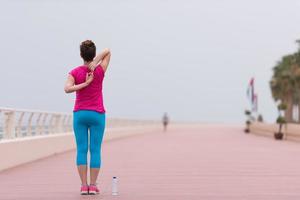 vrouw uitrekken en opwarming omhoog Aan de promenade foto