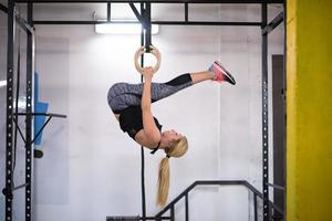 vrouw werken uit Aan gymnastiek- ringen foto